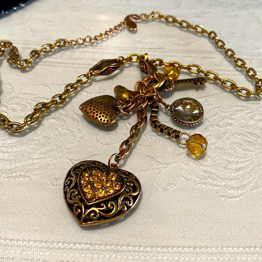 Copper color charm necklaces about 16 in long unknown brand, has a print on it